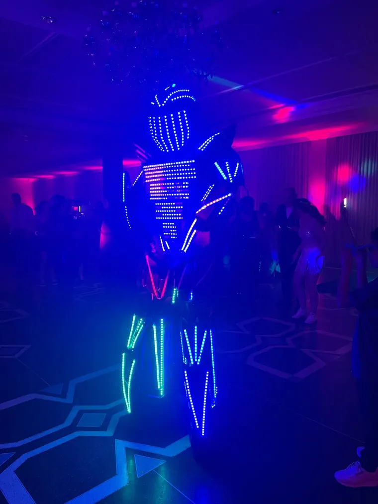 Robô de LED azul iluminando o salão de festas